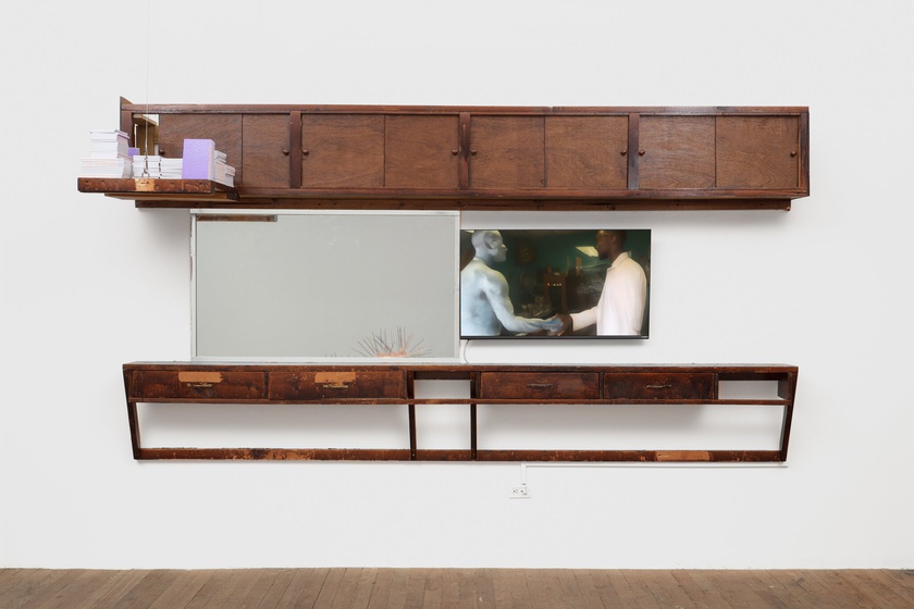 phantom. menace., 2020, 2021, 2022, 2023,  Barbershop fittings, mirror, digital video on monitor, books  71 × 131 × 12 in. (180.34 × 332.74 × 30.48 cm)  video: 3:24 minutes, looped